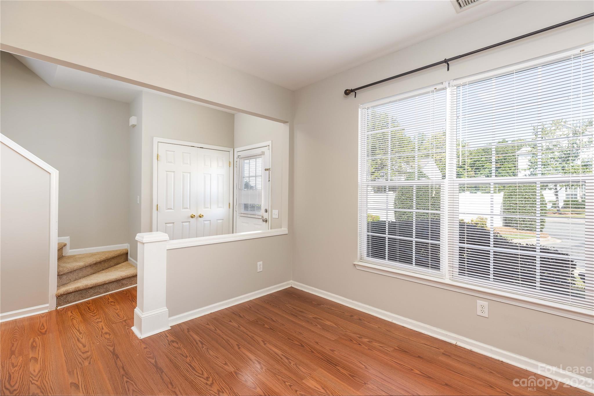 6879 Rothchild Drive Charlotte, NC 28270 - Photo 8 of 19 a view of an empty room with wooden floor and a window