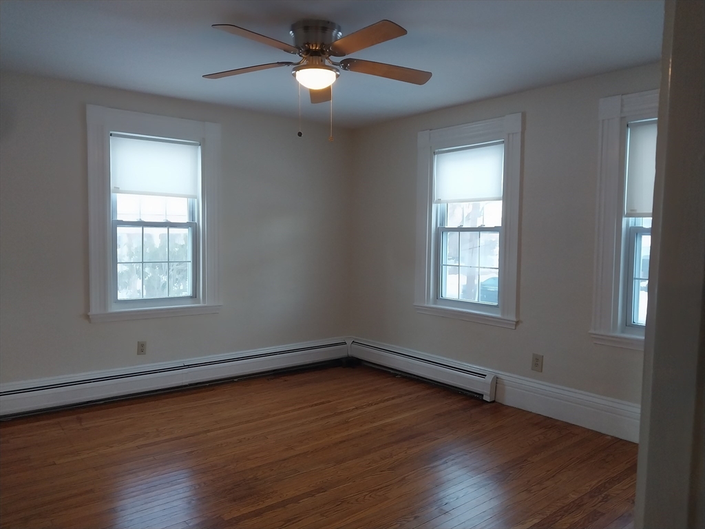 49 Salem Street, Unit 1 Haverhill, MA 01835 - Photo 12 of 16 a view of an empty room with wooden floor and a window