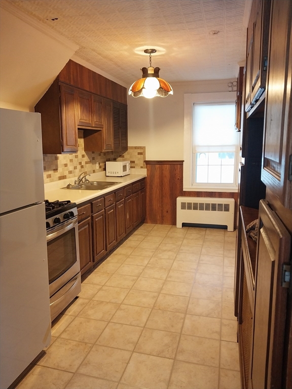49 Salem Street, Unit 1 Haverhill, MA 01835 - Photo 5 of 16 a kitchen with stainless steel appliances a sink stove and refrigerator