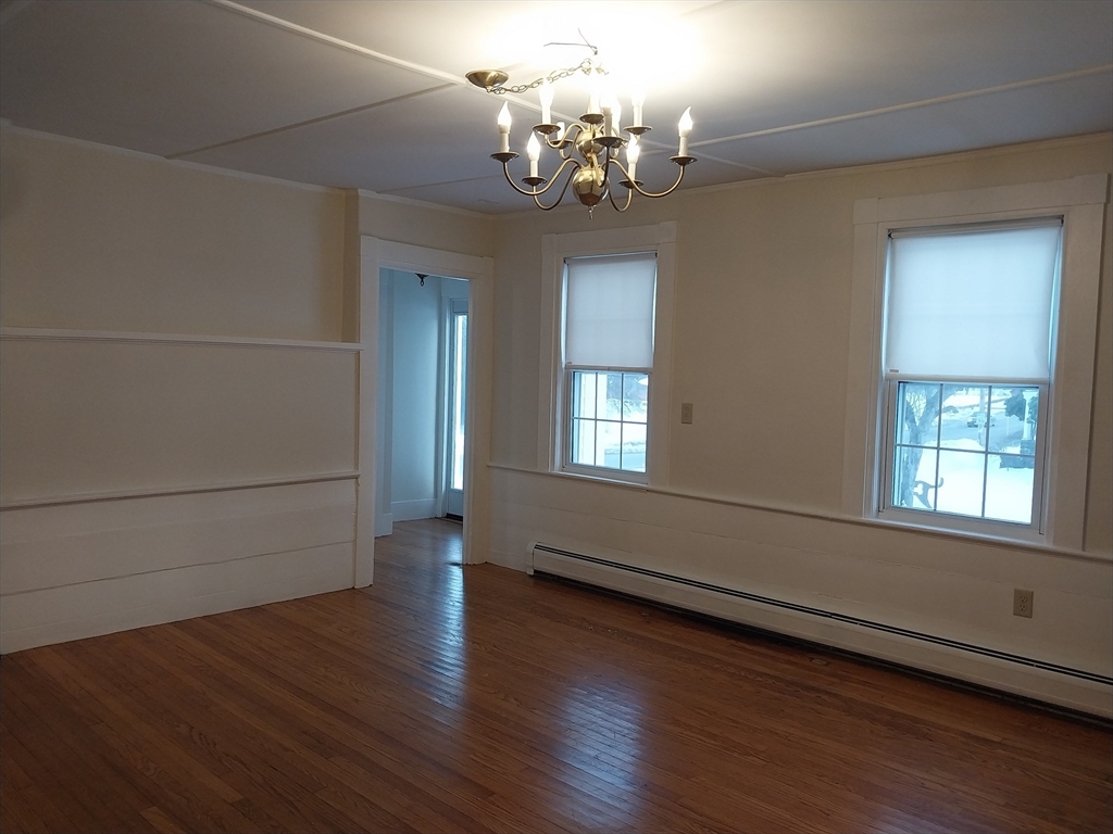 49 Salem Street, Unit 1 Haverhill, MA 01835 - Photo 7 of 16 an empty room with wooden floor chandelier and windows
