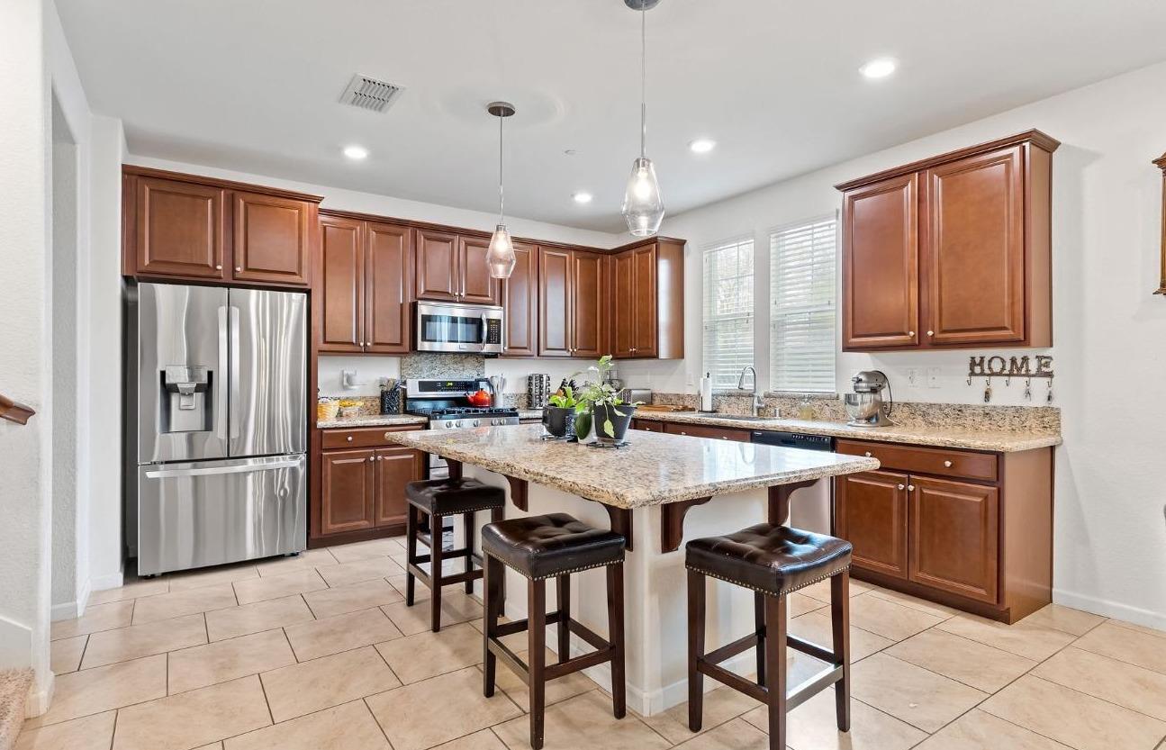 4217 Bob Doyle Drive Roseville, CA 95747 - Photo 1 of 1 a kitchen with stainless steel appliances granite countertop a refrigerator a sink a stove a dining table and chairs