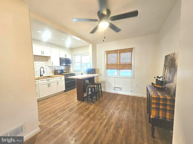 a kitchen with stainless steel appliances a stove a sink a microwave a refrigerator a stove and white cabinets