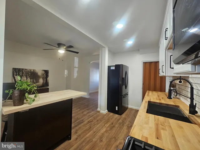 a kitchen with stainless steel appliances granite countertop a refrigerator a sink and white cabinets