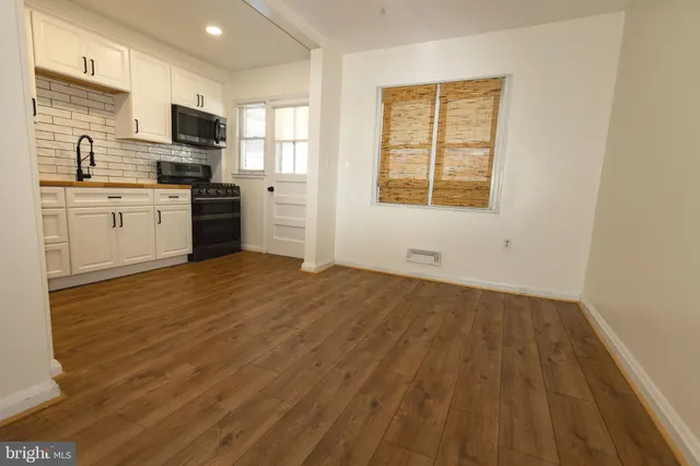 a view of a hallway with wooden floor and closet area