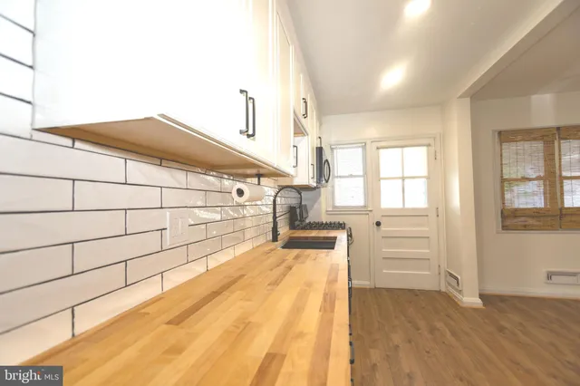 a kitchen with stainless steel appliances a sink cabinets and wooden floor