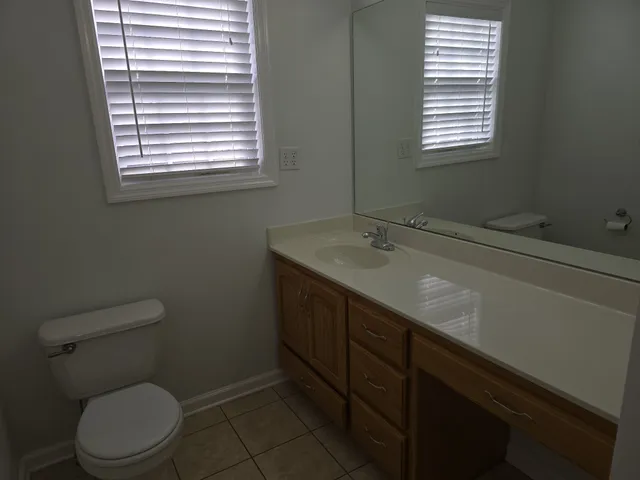 a bathroom with a sink a toilet and a window
