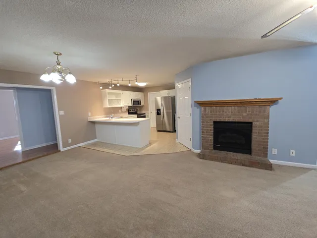 a view of a livingroom with a fireplace and chandelier fan