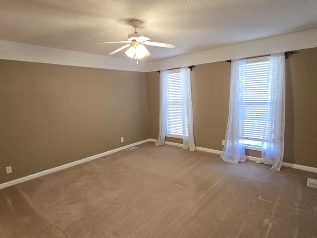an empty room with chandelier fan