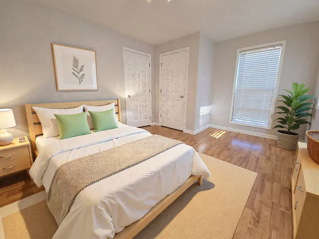 a bedroom with bed and a potted plant