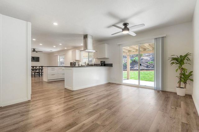 a view of kitchen with refrigerator and wooden floor
