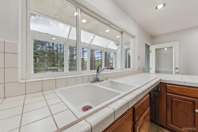 a view of a kitchen with a sink and large window