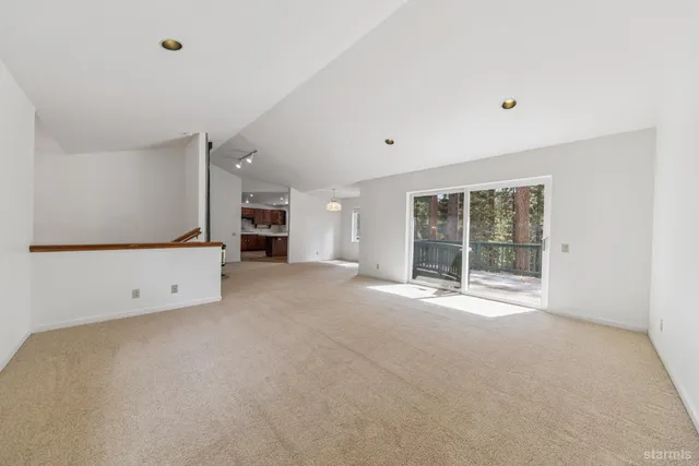 a view of an empty room with a fireplace and a window