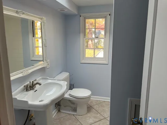 a bathroom with a sink toilet a mirror and a window