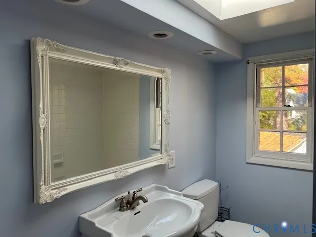 a bathroom with a sink mirror toilet and shower