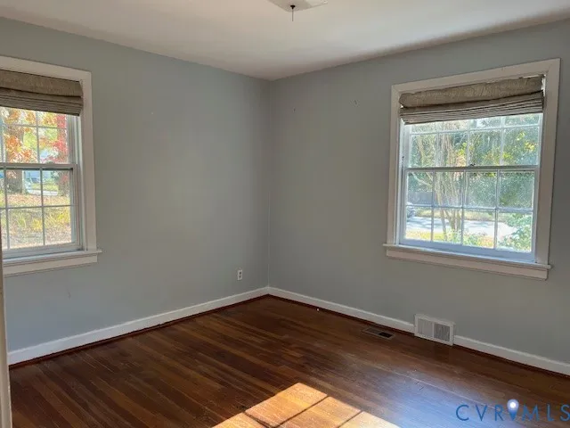 a view of a room with wooden floor and windows