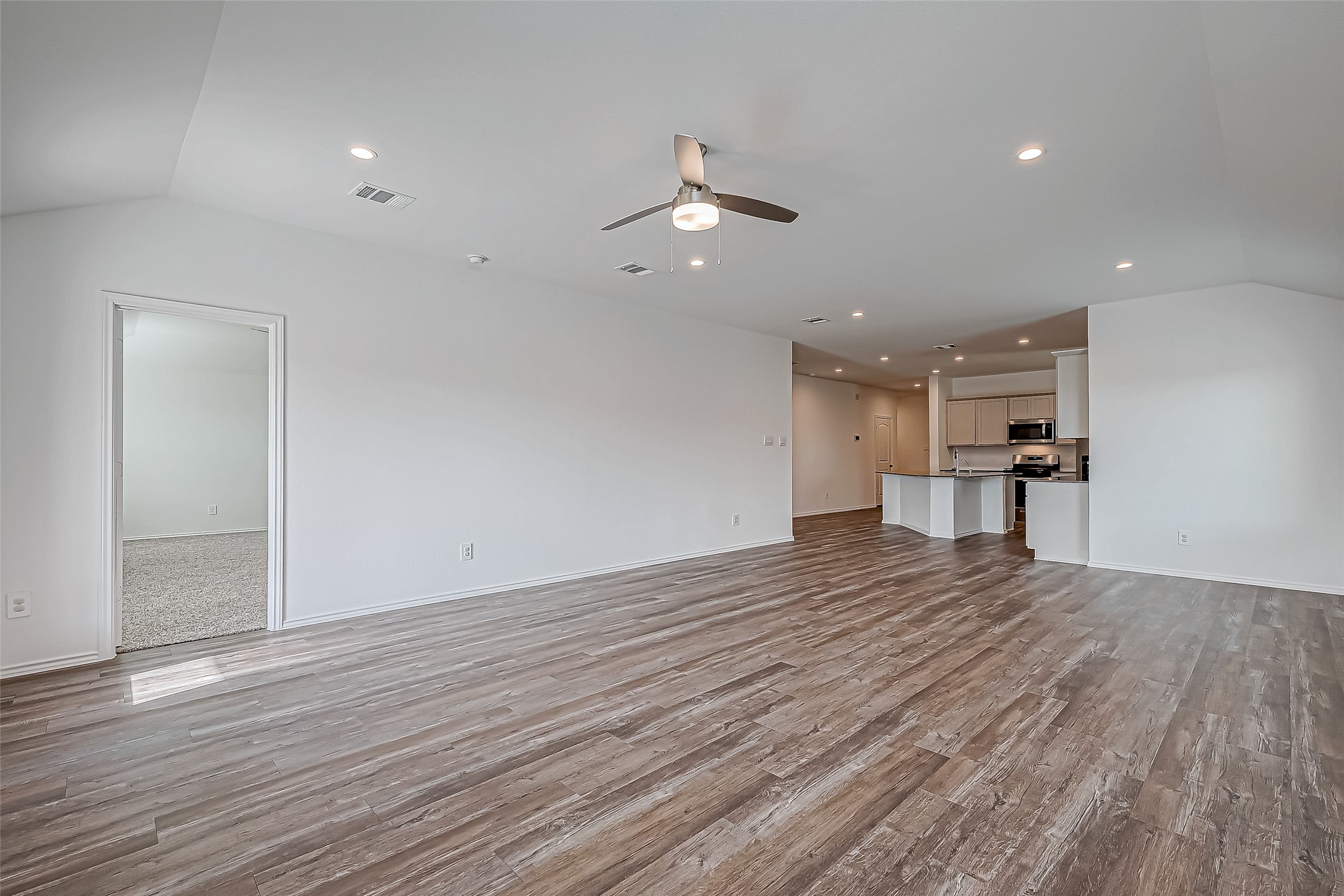 532 Comal Trail Dayton, TX 77535 - Photo 4 of 26 wooden floor in an empty room with a kitchen
