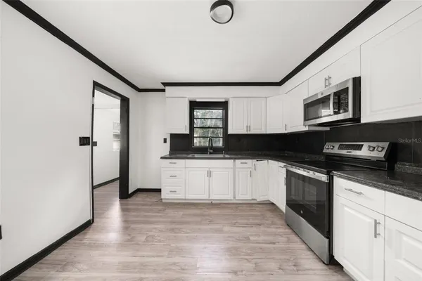 a kitchen with stainless steel appliances granite countertop a stove a sink and a refrigerator