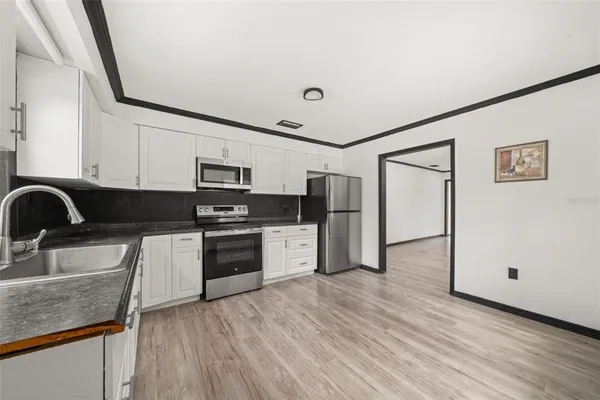 a kitchen with stainless steel appliances granite countertop a refrigerator sink and stove