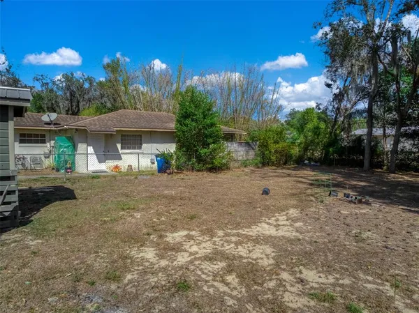 a view of a house with a yard and sitting area