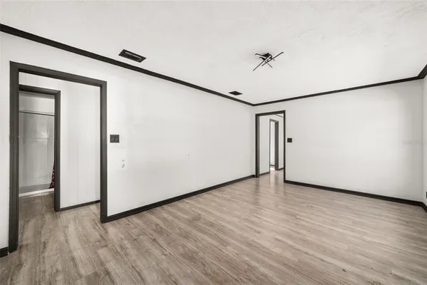 a view of a livingroom with wooden floor and a refrigerator