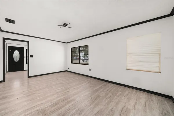 an empty room with windows and ceiling fan