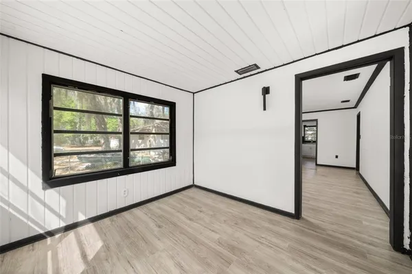 a view of a big room with wooden floor and windows