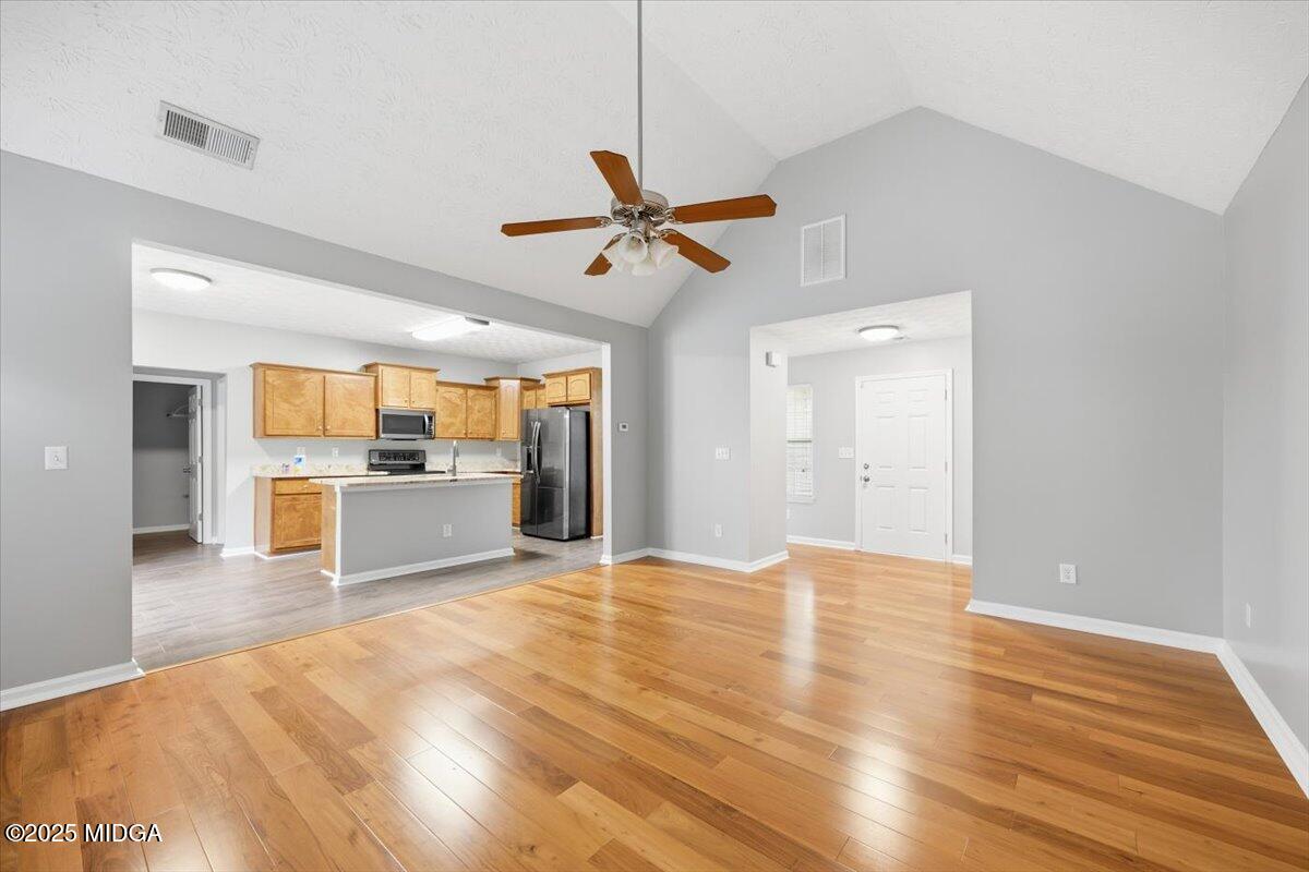 2764 Dames Ferry Road Forsyth, GA 31029 - Photo 3 of 30 a view of a kitchen with wooden floor and a ceiling fan
