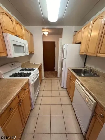 a kitchen with a sink a refrigerator and cabinets