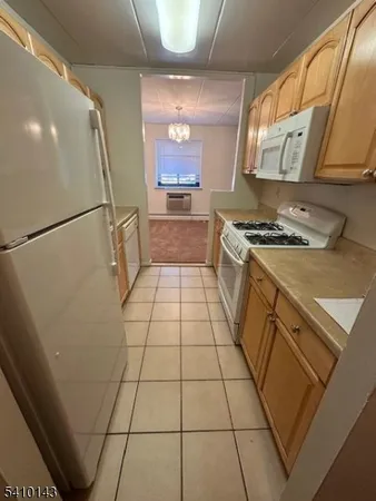 a kitchen with granite countertop a stove a refrigerator and a cabinets