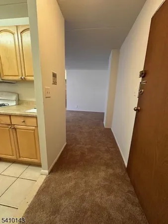 a view of a kitchen with white cabinets and wooden floor
