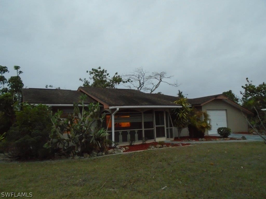 113 Rowland Road Lehigh Acres, FL 33936 - Photo 1 of 14 a front view of a house with a garden