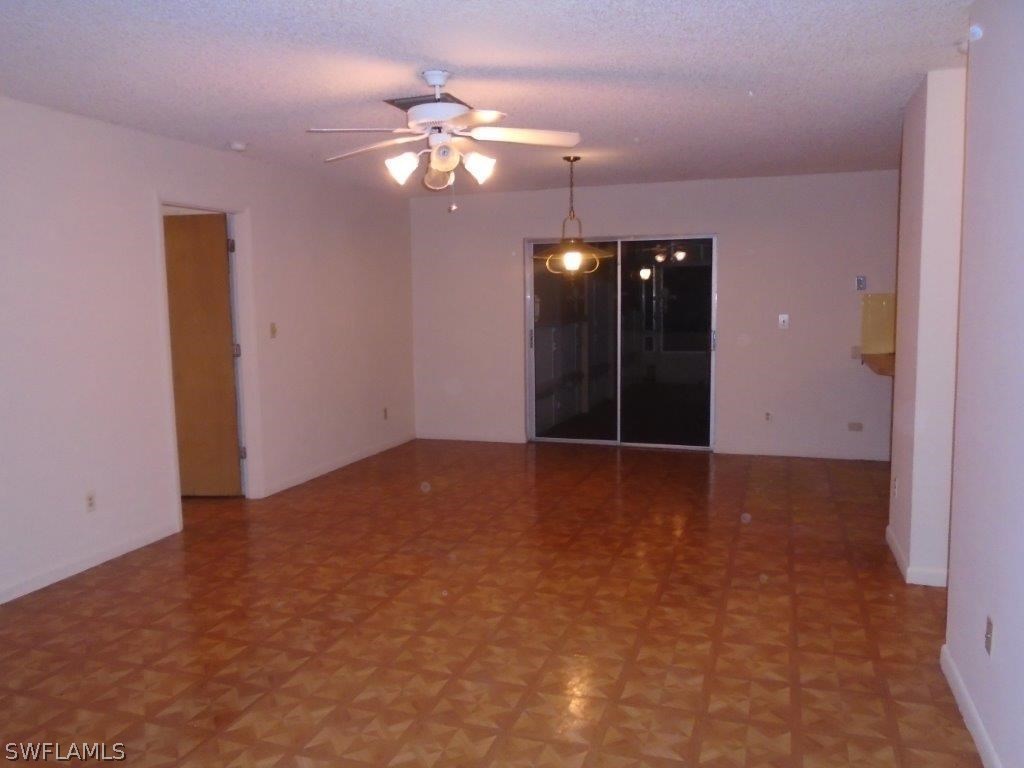 113 Rowland Road Lehigh Acres, FL 33936 - Photo 3 of 14 a view of an empty room with a chandelier fan