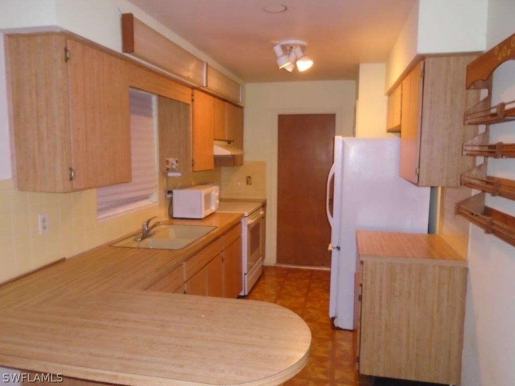 113 Rowland Road Lehigh Acres, FL 33936 - Photo 4 of 14 a room with wooden cabinets and bed