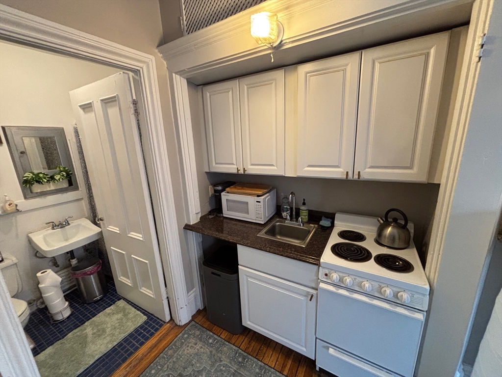 98 Charles Street, Unit 9 Boston, MA 02114 - Photo 5 of 7 a kitchen with a sink and appliances