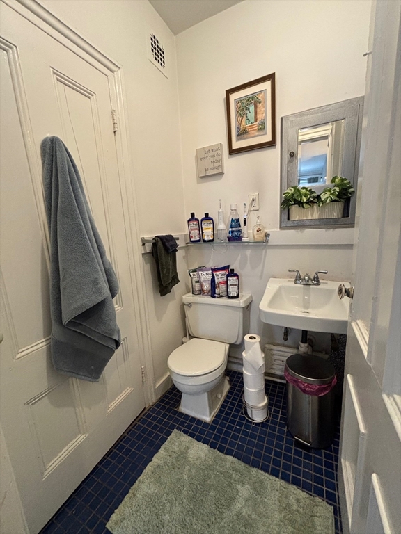 98 Charles Street, Unit 9 Boston, MA 02114 - Photo 6 of 7 a bathroom with a toilet a sink and a mirror