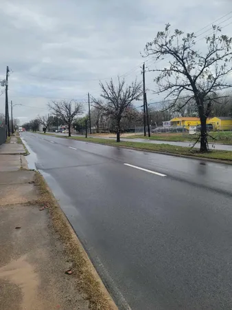 a view of a house with a big yard and large trees