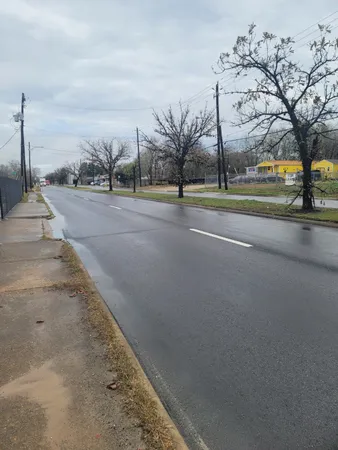 a view of a building with a big yard and large trees