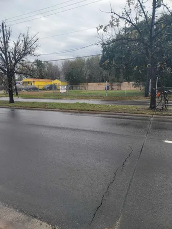 a view of a house with a big yard and large trees