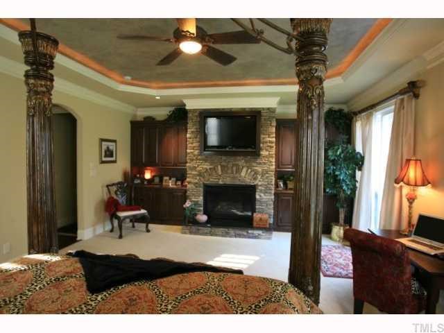 9004 Albatross Court Raleigh, NC 27613 - Photo 5 of 12 a living room with furniture a flat screen tv and a fireplace