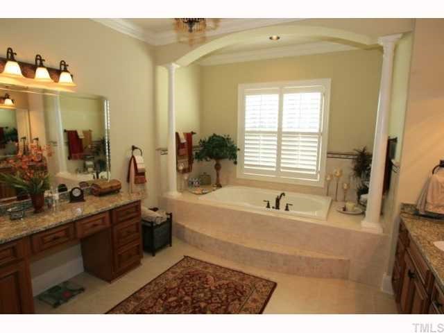9004 Albatross Court Raleigh, NC 27613 - Photo 6 of 12 a bathroom with a tub sink and mirror