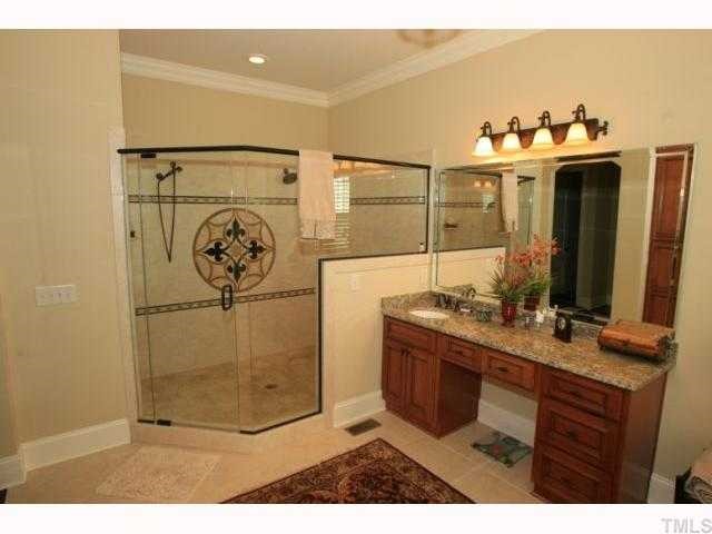 9004 Albatross Court Raleigh, NC 27613 - Photo 7 of 12 a bathroom with a sink mirror and vanity