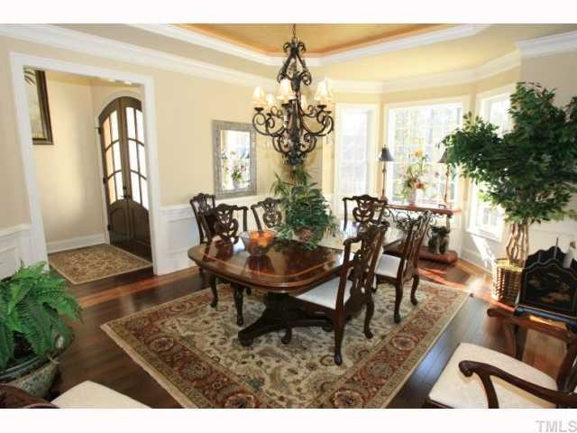 9004 Albatross Court Raleigh, NC 27613 - Photo 8 of 12 a dining room with furniture a chandelier and wooden floor