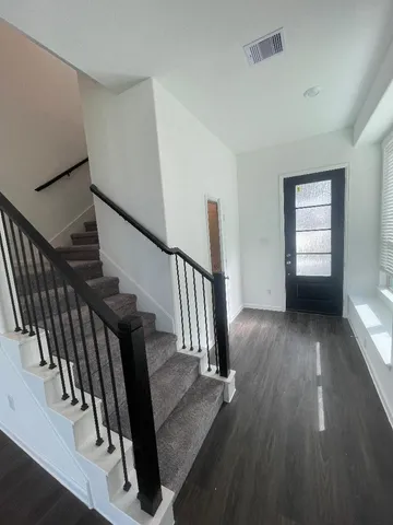 a view of entryway and hall with wooden floor