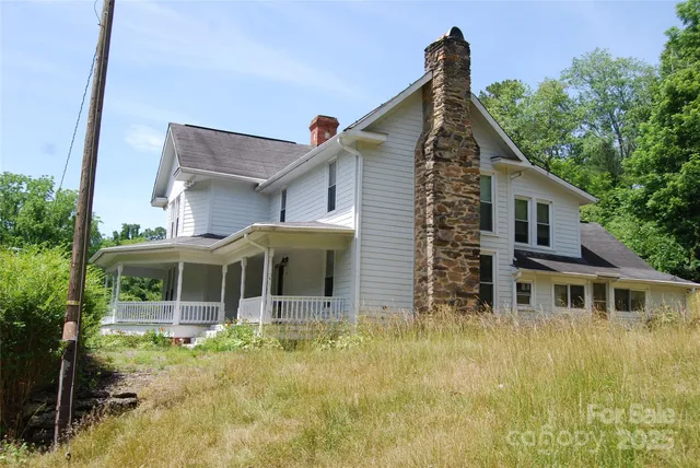 a front view of house with yard and trees in the background