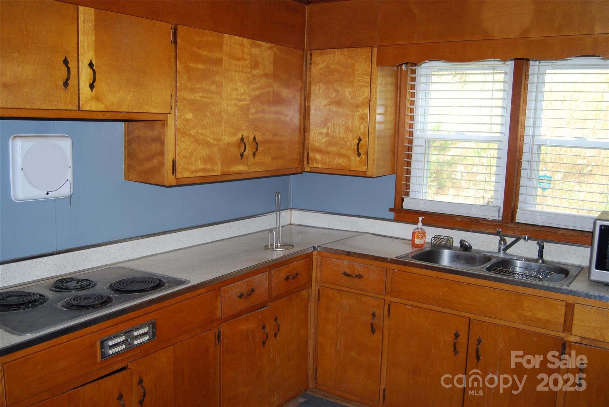 7 Noble Road Fairview, NC 28730 - Photo 24 of 44 a kitchen with blue cabinets and a sink