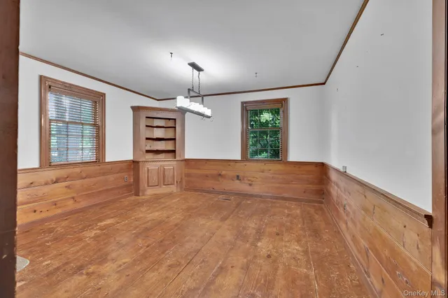 an empty room with windows and fireplace
