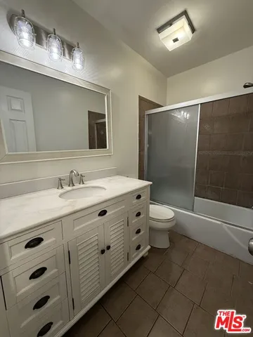 a bathroom with a double vanity sink toilet mirror and bathtub