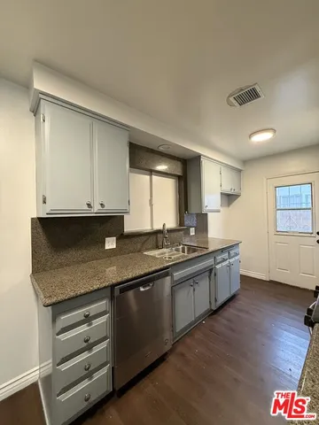 a large kitchen with granite countertop a sink and dishwasher stove top oven