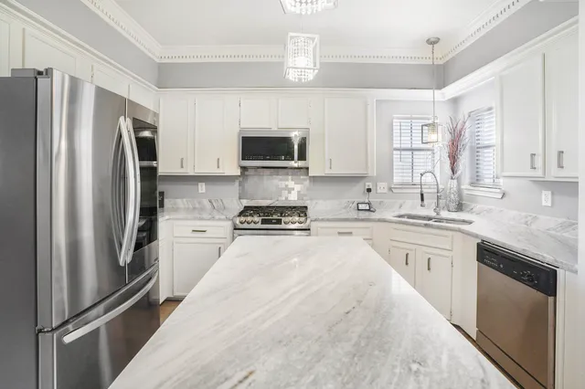 a kitchen with stainless steel appliances a refrigerator sink and microwave