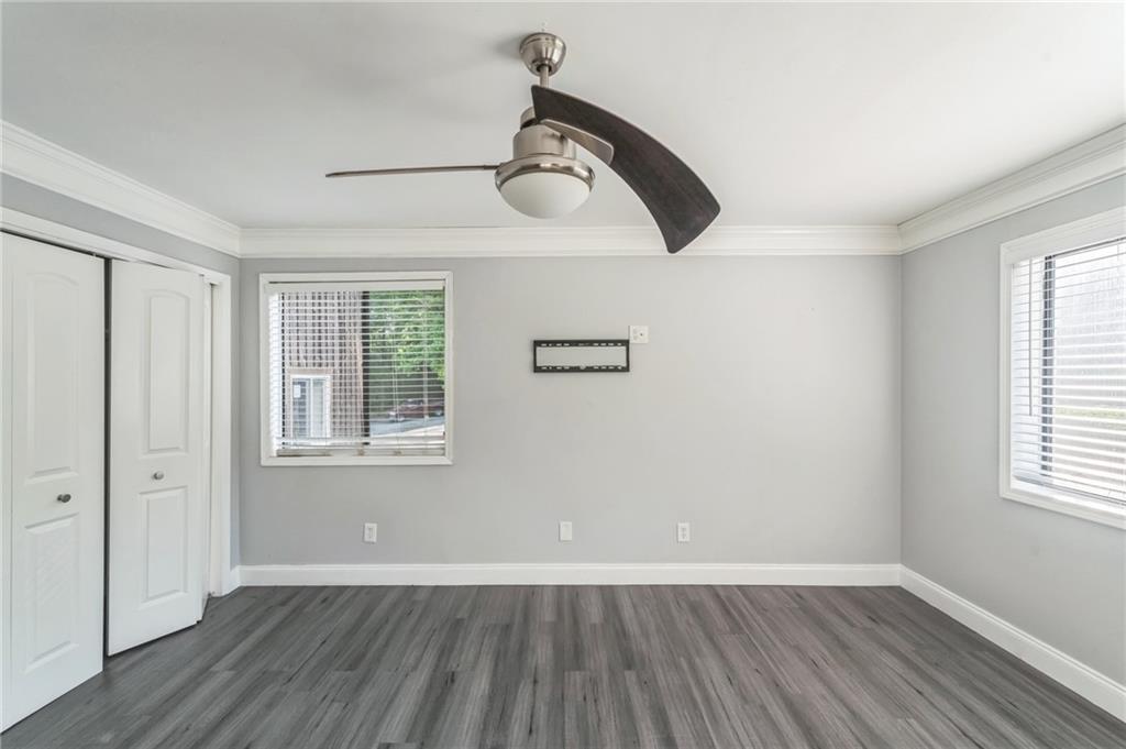 18 Quail Run, Unit A Decatur, GA 30035 - Photo 21 of 28 an empty room with wooden floor ceiling fan and windows